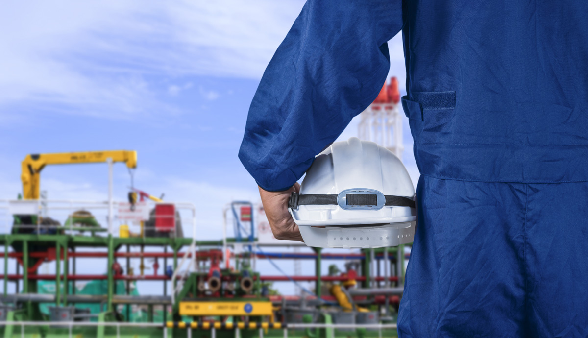 Close up engineer hand in blue mechanic jumpsuit holding white s